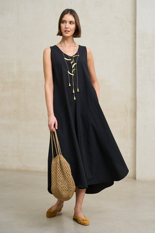 look elegante minimalista mujer vestido negro fluido y bolso